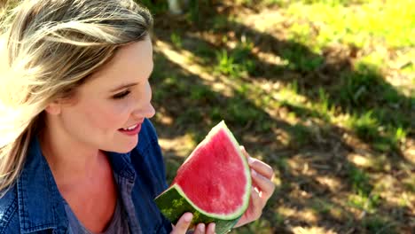 Beautiful-woman-having-watermelon-slice-in-park-4k