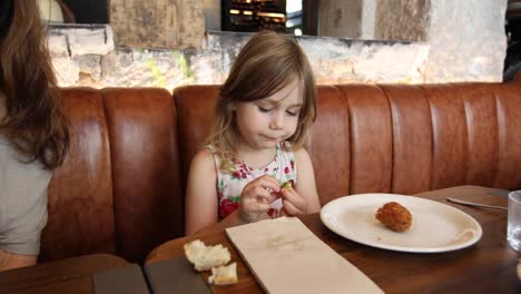 little-child-eating-olive-in-restaurant