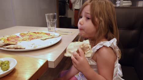 little-girl-in-restaurant-eating-pizza-and-dancing