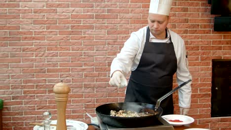 Chef-poner-cucharas-con-especias-a-la-sartén,-mariscos-de-Bielsa