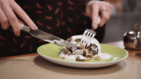 Unrecognizable-girl-eating-dessert-strudel-at-the-restaurant-using-fork-and-knife