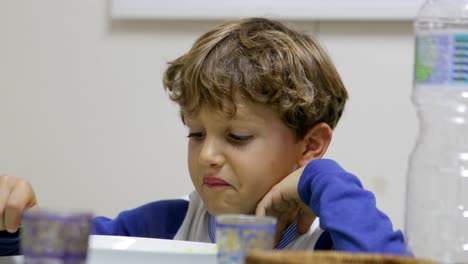 Toma-casual-de-niño-comiendo-sopa.-Chico-joven-guapo-bebiendo-sopa-de-verduras-ocasional-y-cándidamente-en-kicthen-familia-4K