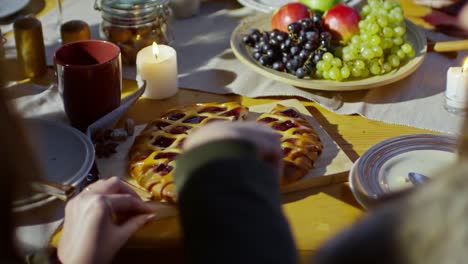 Frau-schneiden-Kuchen-für-Urlaub-Abendessen-mit-Freunden