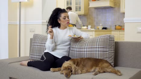 Schöne-Frau-auf-dem-Sofa-entspannen-und-isst-Salat