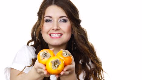 Cheerful-woman-holds-persimmon-kaki-fruits,-isolated