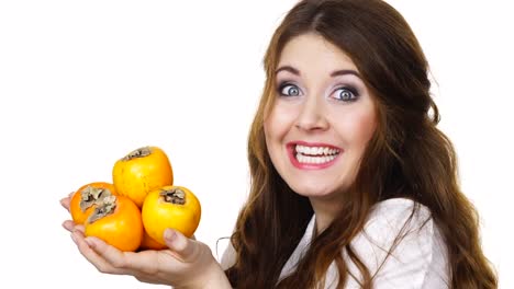 Cheerful-woman-holds-persimmon-kaki-fruits,-isolated