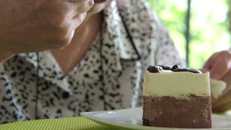 elder-senoir-eating-chocolate-mousse-cake-at-cafe.-asian-elderly-woman-sitting-and-tasting-delicious-dessert-at-restaurant.