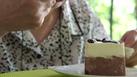 Elder-Senoir-Schokoladenmousse-Kuchen-im-Café-Essen.-asiatische-ältere-Frau-sitzt-und-köstliches-Dessert-im-Restaurant-schmecken.