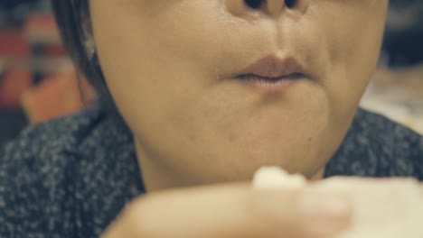 close-up-shot-:-Asian-woman-eating-a-steam-bun