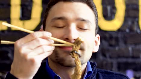 Young-man-enjoys-a-smell-of-tasty-squid-in-batter-and-recommend-dish-on-camera