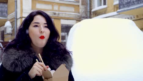 Joven-Coreano-come-una-pasta-en-la-calle-durante-nevadas