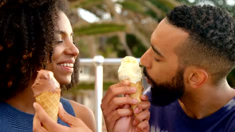 Couple-eating-ice-cream-cone-at-beach-4k