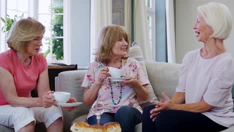 Senior-Female-Friends-Enjoying-Afternoon-Tea-At-Home-Together