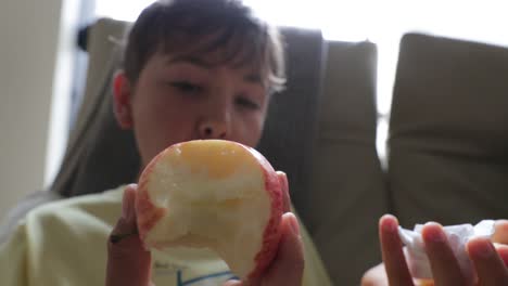 Child-eating-apple-indoors.-Young-boy-eats-healthy-fruit-in-4K