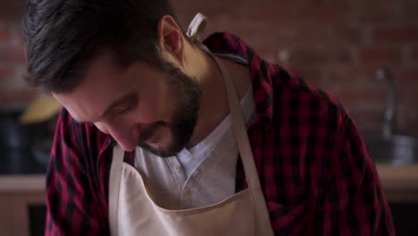 man-in-apron-cooking-at-the-kitchen