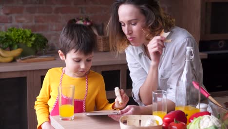 Mutter-beobachten-sein-Sohn-spielen-auf-digitale-tablet