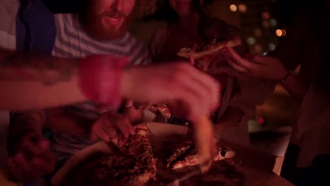 Junge-Hipster-Freunde-Essen-Pizza-auf-Dachterrasse-Sommer-Nacht-party