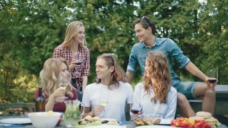 Menschen-jubeln-mit-Getränken-bei-Outdoor-Dinner-Party