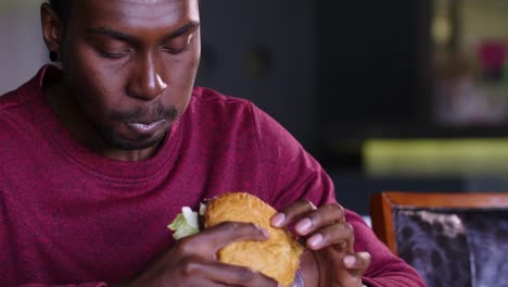 glücklich-afroamerikanische-dicker-Mann-einen-Hamburger-Essen.