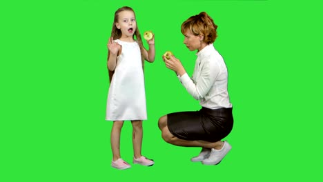 Madre-feliz-comiendo-comida-sana-hija-sobre-una-pantalla-verde-Chroma-Key