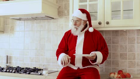 Santa-sits-on-kitchen-furniture-and-eats-cookies-with-milk