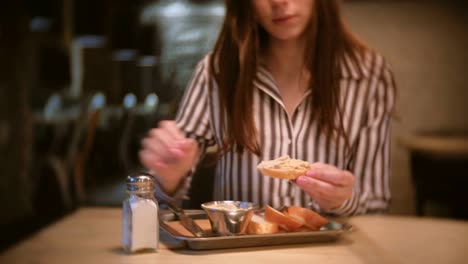 Frau-Brünette-Salz-Sandwich-mit-Pastete-im-Café.