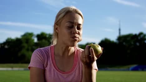 Mujer-comer-manzana-en-luz-del-sol-en-el-campo