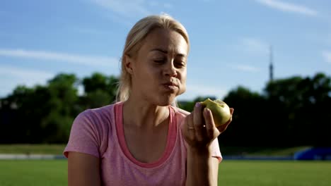 Frau-zu-essen-Apfel-im-Sonnenlicht-auf-Feld