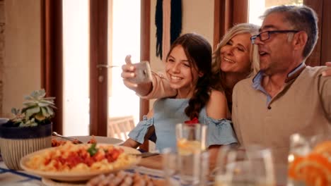 Großeltern-unter-Selfies-mit-Enkelin-während-Familie-Mittagessen-im-restaurant