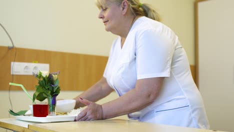 Enfermera-traiga-comida-a-paciente-en-una-habitación-de-hospital