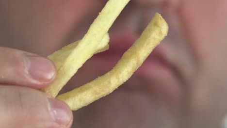 Un-hombre-comiendo-papas-fritas-con-salsa-de-tomate