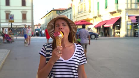 Piombino,-Livorno,-Tuscany,-Italy.-A-girl-is-walking-down-the-street-eating-an-ice-cream