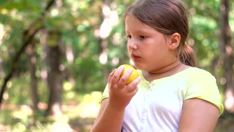 Kleine-Mädchen-Porträt-essen-Apfel-im-freien-Apfel-an-einem-Sommertag