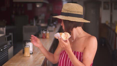 Mujer-comiendo-Hot-Dog-en-el-café