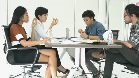 Business-people-eating-pizza-is-break-time-and-meeting-team-together-for-success-project.-Concept-of-teamwork,-relax,-creative-working-and-sharing-idea.