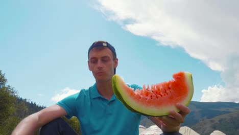 Porträt-gut-aussehender-Mann-essen-frische-Wassermelone-am-Sommertag-im-freien