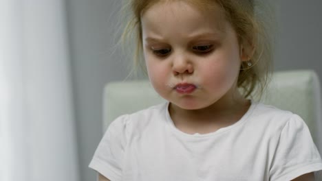 Adorable-Girl-Talking-while-Eating-Breakfast