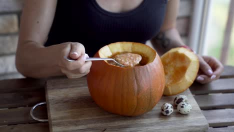 Mujer-joven-feliz-comiendo-sopa-de-calabaza-en-cocina