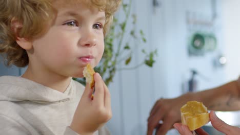 Entzückende-kleine-Junge-essen-Brot