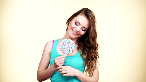 Woman-smiling-girl-with-lollipop-candy-on-green-4K