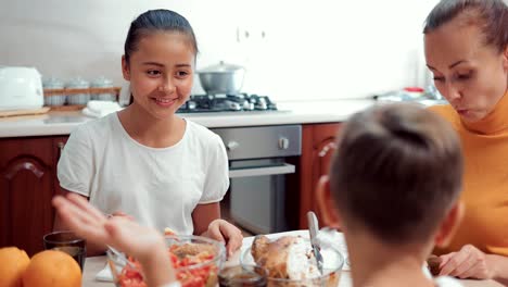 Happy-family-is-eating-dinner-in-the-kitchen-and-having-fun-with-each-other