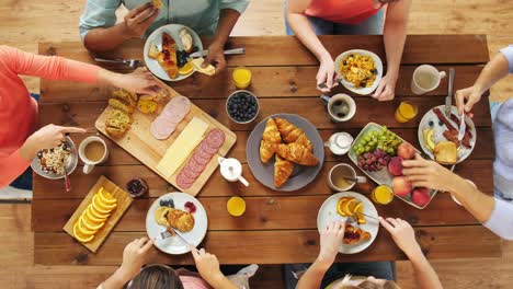 Gruppe-von-Menschen,-die-Essen-am-Tisch-mit-Essen