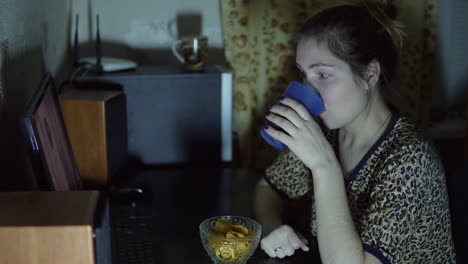 young-girl-watching-the-movie-at-the-computer-and-eating-chips.