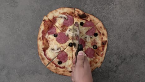 Mano-del-hombre-cortando-la-pizza