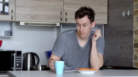 Sueño-joven-tomando-café-en-la-cocina