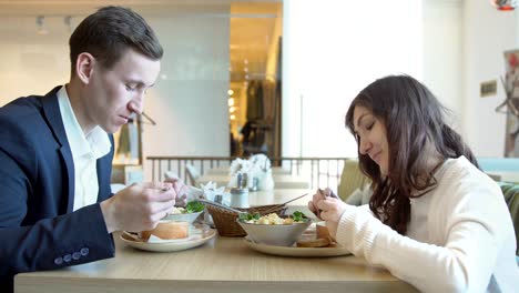 Junger-Mann-und-Frau-in-einem-Café-zu-Mittag