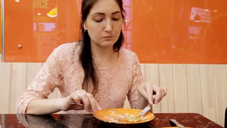 Attractive-girl-eating-a-pancake-with-ice-cream-in-cafe,-close-up