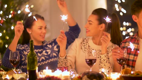 Glückliche-Freunde-mit-Wunderkerzen,-die-Weihnachts-Dinner-zu-Hause