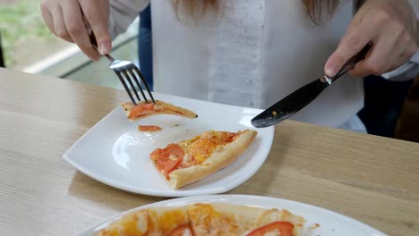 Brünette-Frau-in-einem-Café-Pizza-essen.-Schnelle-und-ungesunde-Ernährung