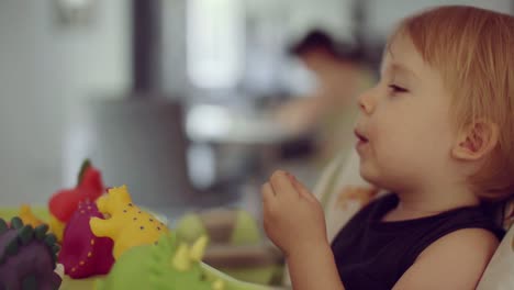 little-boy-sitting-on-high-chair-eating-sandwich